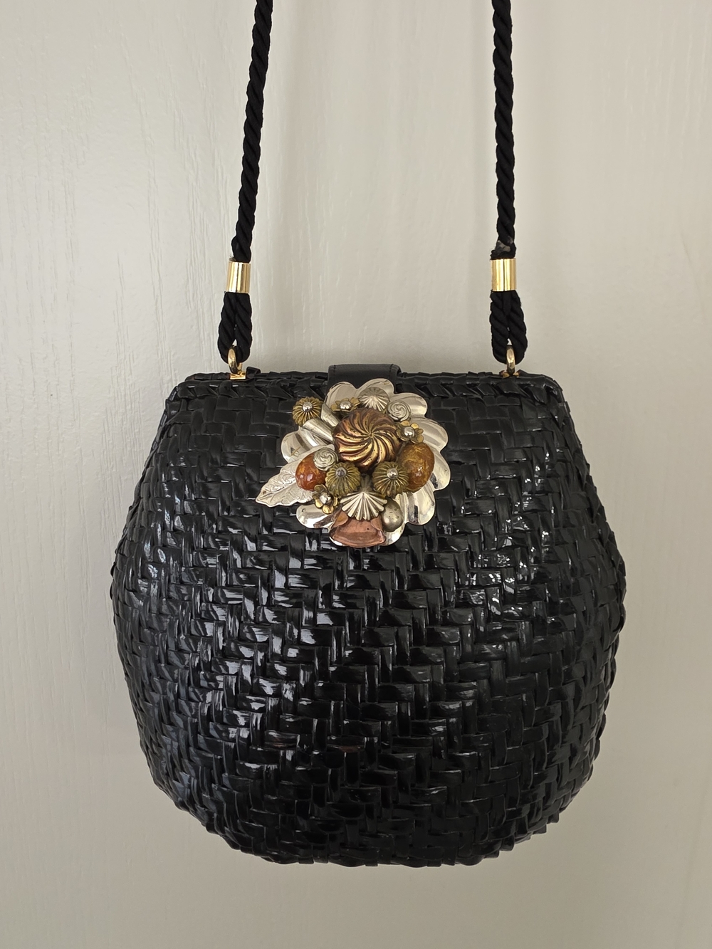 Rodo Black Woven Crossbody with Floral Metal Accent